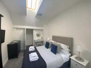 een slaapkamer met een groot bed met blauwe kussens bij The Loft in Anstruther