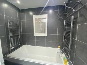 een badkamer met een bad en een foto aan de muur bij The Loft in Anstruther +21 foto's