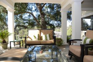 una veranda con divano e tavolino in vetro di Arroyo Vista Inn a Los Angeles