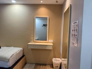 a small bedroom with a bed and a mirror at Zetta Roomstay in Kuala Lumpur