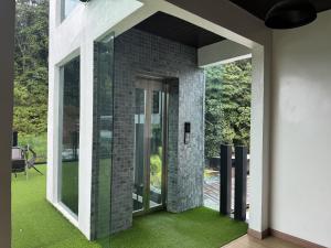 a glass extension to a house with green grass at Zetta Roomstay in Kuala Lumpur