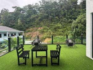 a patio with a table and chairs on the grass at Zetta Roomstay in Kuala Lumpur