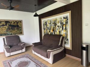 a living room with a couch and a chair at Zetta Roomstay in Kuala Lumpur