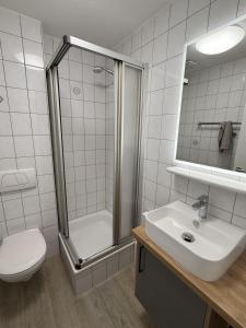 een badkamer met een douche, een toilet en een wastafel bij Schmidteinander in Norderney