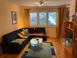 a living room with a black couch and a table at Sonnenalpe ckpk in Hermagor