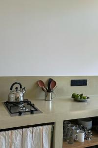 a kitchen counter with a stove with a pot on it at Madi House in Matara +11 photos