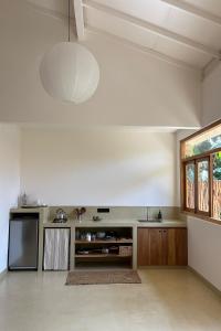a large white kitchen with a large pendant light at Madi House in Matara