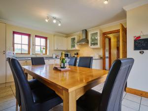 a kitchen and dining room with a wooden table and chairs at Hazel Lodge in Blairgowrie
