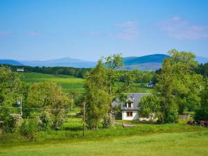 a house in the middle of a field with trees at Hazel Lodge in Blairgowrie