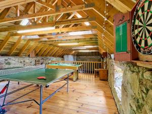 a room with two ping pong tables and a dartboard at Hazel Lodge in Blairgowrie
