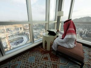 a person sitting in a chair in front of a window at Swissotel Makkah in Makkah
