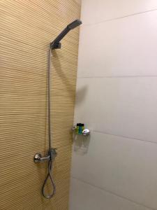 een douche in een badkamer met een douchekop bij Yaya Hostel in Fort de lʼEau