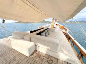 a boat with couches and pillows on the deck at Shared Boat Komodo 3 days 2 Night in Komodo Labuan Bajo Airport