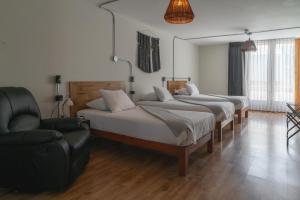 a bedroom with two beds and a chair and a couch at qema Arequipa in Arequipa +73 photos