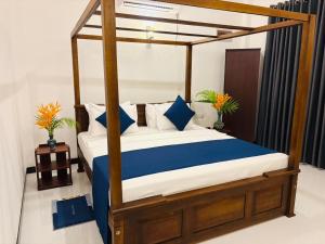 a bedroom with a canopy bed with blue and white pillows at Sea Breeze Heaven in Tangalle