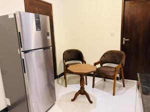 a kitchen with two chairs and a refrigerator at Sea Breeze Heaven in Tangalle
