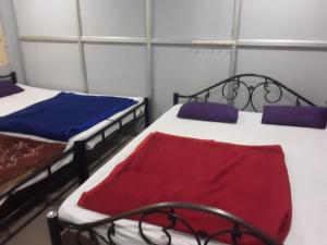 una stanza con due letti in una stanza di tre mesi e tre mesi in cui si trova la stessa cosa. di SGH Mysore dorm bus rail station a Mysore 1 altra foto