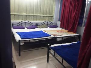 2 letti in una camera con cuscini viola di SGH Mysore dorm bus rail station a Mysore