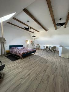 a large room with a bed and a table at La Flore in Baraqueville