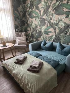 a blue couch in a living room with a wall at VillaKrocker - ElbeRadweg trifft WandKunstwerk in Burg bei Magdeburg