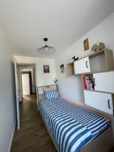 a bedroom with a bed with blue and white stripes at La Flore in Baraqueville