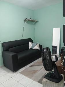 een zwarte bank in een woonkamer met een stoel bij Otimo Apartamento em Maceió Proximo ao Centro in Maceió