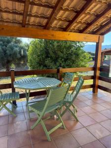 a patio with a table and chairs on a deck at Villa T3 avec piscine in Sollacaro
