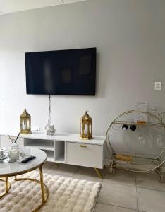 un soggiorno con una TV a parete di Elevare suites a Nelspruit
