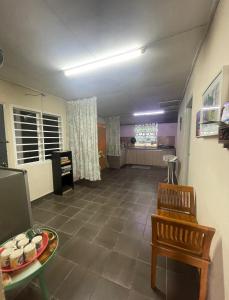 een woonkamer met een tafel en een stoel bij D'Ashikin Village Stay in Seremban