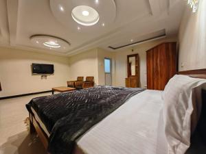 una camera da letto con un letto grande e una TV a schermo piatto di The Hill Bunk Heights Ooty a Ooty