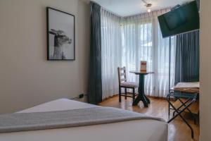 a bedroom with a bed and a table and a window at qema Arequipa in Arequipa