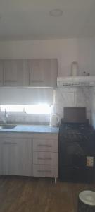 een keuken met een zwarte kachel en een wastafel bij cabañas sunrise in Merlo +22 foto's