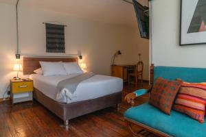 a hotel room with a bed and a chair at qema Arequipa in Arequipa