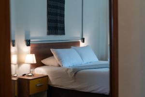 a bedroom with a bed and a night stand with a lamp at qema Arequipa in Arequipa