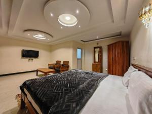 a bedroom with a large bed and a tv at The Hill Bunk Heights Ooty in Ooty +17 photos