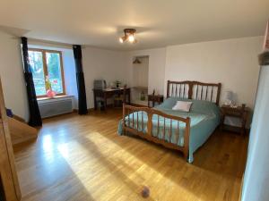 a bedroom with a bed and a wooden floor at La petite Chalvignacoise in Chalvignac