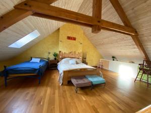 a attic bedroom with two beds and a table at La petite Chalvignacoise in Chalvignac