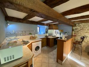 a kitchen with a sink and a washing machine at La petite Chalvignacoise in Chalvignac
