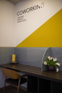 een bureau met een vaas met bloemen erop bij HOTEL OSCAR GOLD in Montes Claros