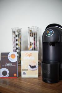 een koffiezetapparaat en een kopje koffie op een tafel bij HOTEL OSCAR GOLD in Montes Claros