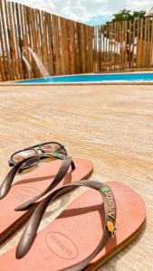 a pair of flip flops with a pair of glasses on them at Chalé M in Serra do Cipo +14 photos