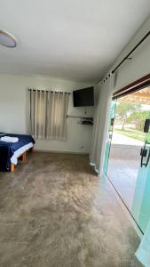 an empty room with a bed and a sliding glass door at Chalé M in Serra do Cipo