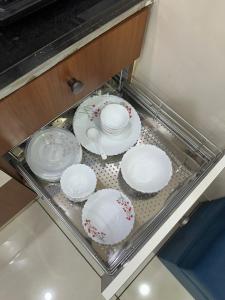 een groep borden en kommen die in een lade staan bij Ikigai Stay 3BHK Duplex in Ujjain