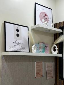 een plank met twee foto's en boeken erop bij Ikigai Stay 3BHK Duplex in Ujjain