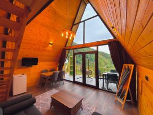 a living room with a table and a large window at AĞARaN SUİT BUNGALOV in Rize