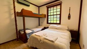Giường trong phòng chung tại Casa 02 Vale Boa Vista - Casa em Condomínio Exclusivo com Vista para as Montanhas e Área de Lazer Completa