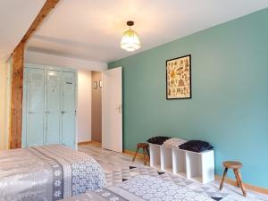 a bedroom with blue walls and a bed and a chair at La Filature in Rochesson