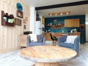 a room with a table and two chairs and a kitchen at La Filature in Rochesson