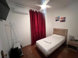 una camera con letto e tenda rossa di Apartalux Isla Cristina a Isla Cristina