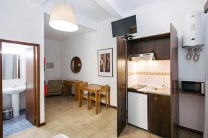 a kitchen with a sink and a table in a room at Murças74 - Studio Apartments in Funchal